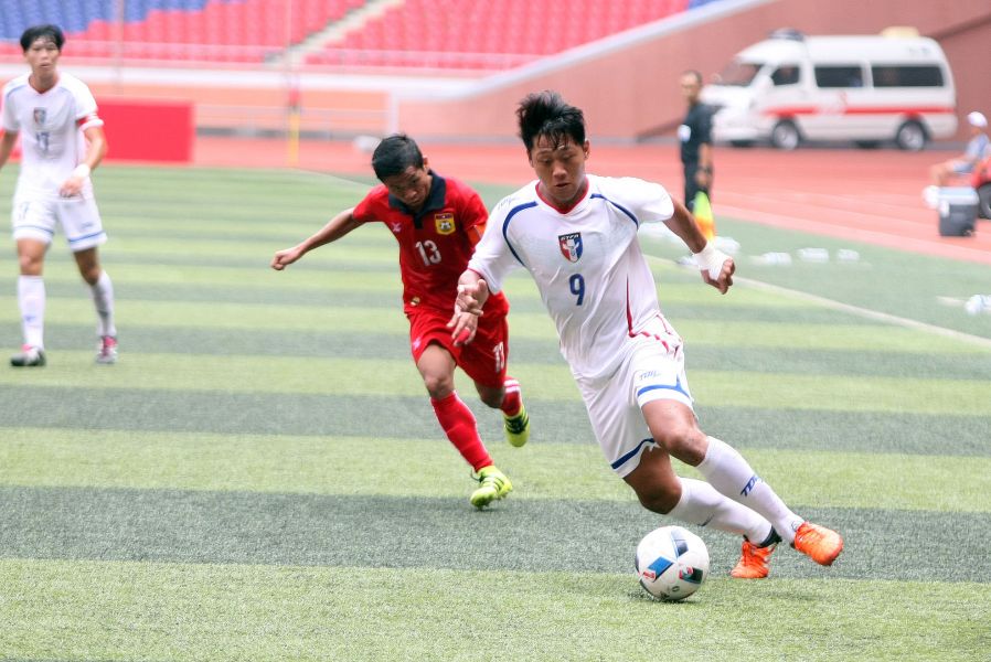 中華隊李祥偉(右)盤球閃過寮國防守。中華民國足球協會提供