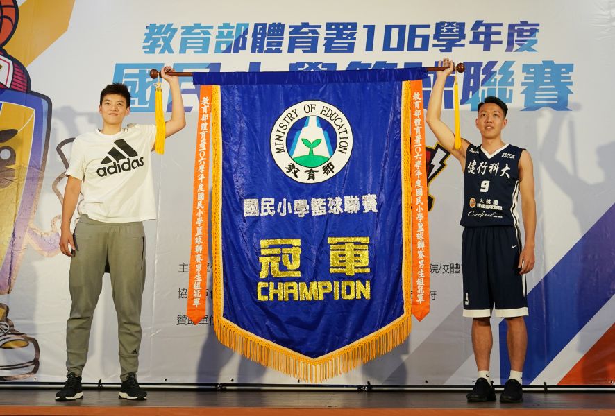 國小籃球聯賽記者會_臺北世大運選手王維琳(左)與劉人豪(右)共同揭曉冠軍旗並給予小選手勉勵。大會提供 
