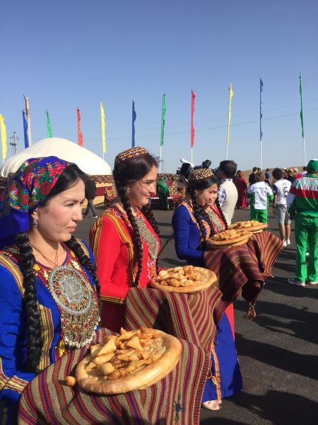 土庫曼當地婦女手捧傳統食物，迎接世界各地媒體到來。體記提供