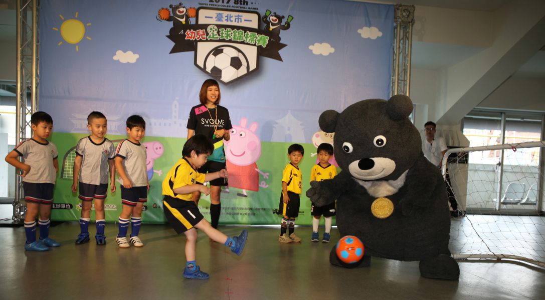 足球小將射門，台北世大運吉祥物熊讚守門。李天助攝
