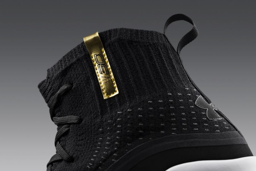 鞋領上的金色鞋標，完美地與黑色鞋身產生反差效果，外側標有羅馬數字的Curry 4字樣「IV SC」。UA提供