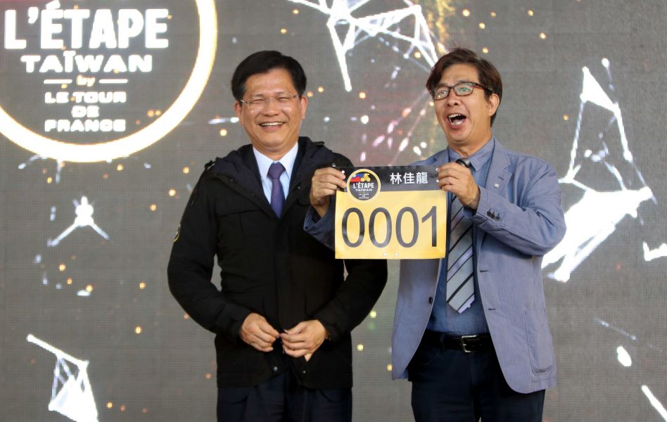 台灣環法業餘自行車賽協會理事長姜海南(右)為台中市長林佳龍準備了0001號號碼布。騰風國際整合行銷／提供。