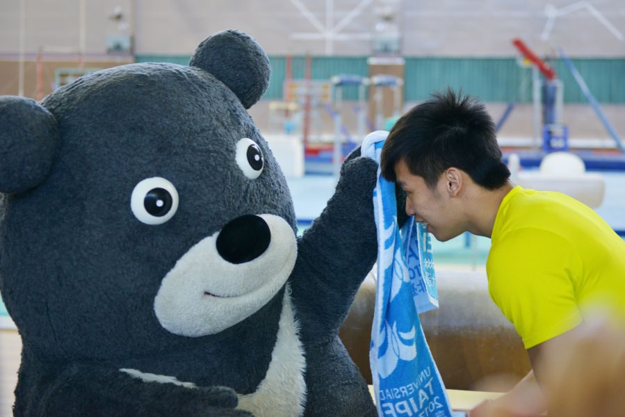 熊讚為表演鞍馬動作的奧運體操國手李智凱擦汗。 （國家運動訓練中心提供）