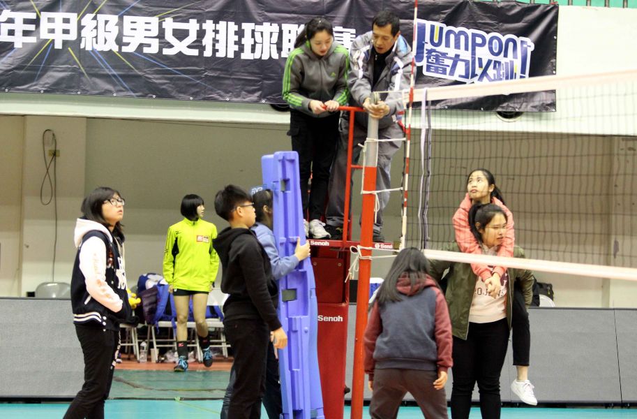 嘉義高商排球隊同學們在中華排協場地組彭文龍(上右)指導下架設球網。林嘉欣／攝影。