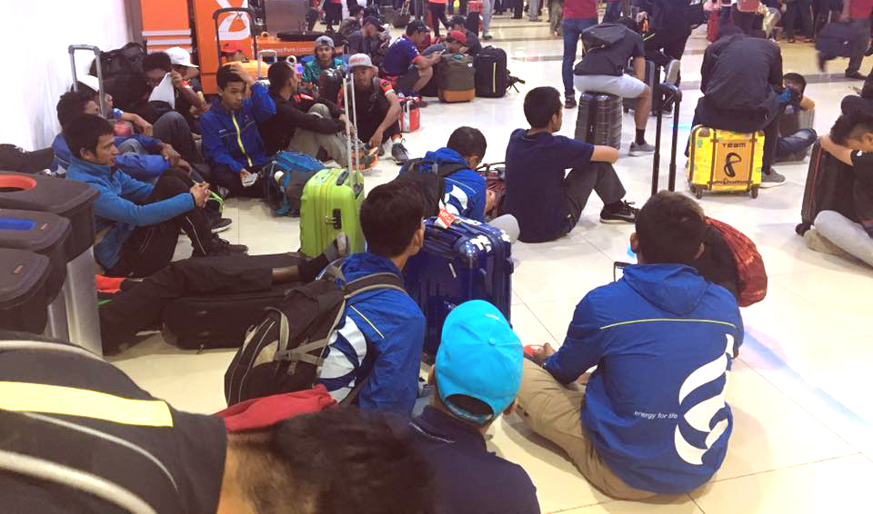 台灣前勁車隊克難地席地而坐在機場候機。台灣前勁隊／提供。