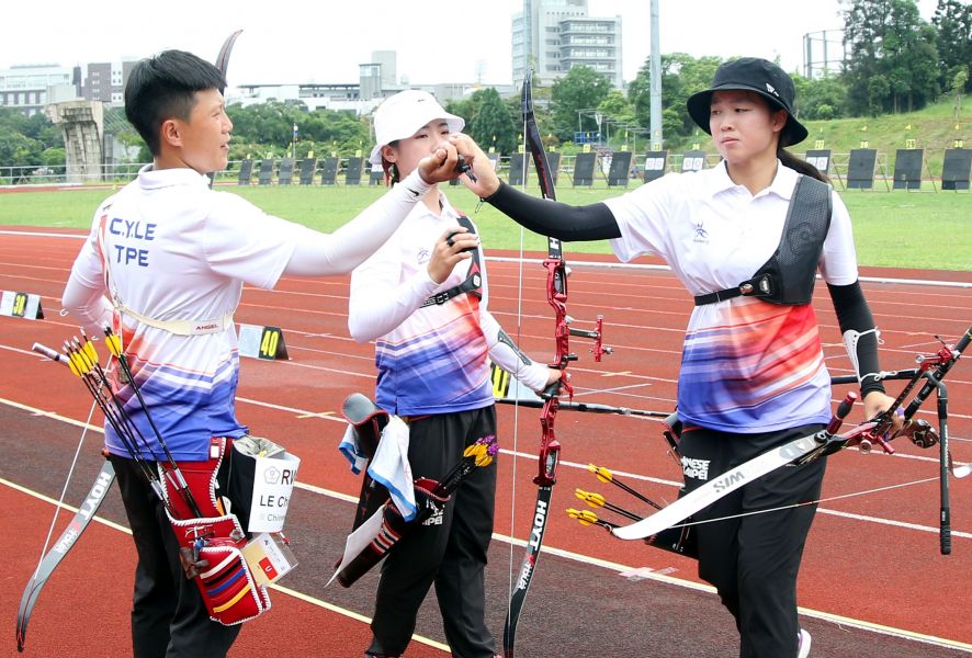 中華反曲弓女子隊譚雅婷(中)、雷千瑩(左)和彭家楙(右)互相打氣。林嘉欣／攝影。