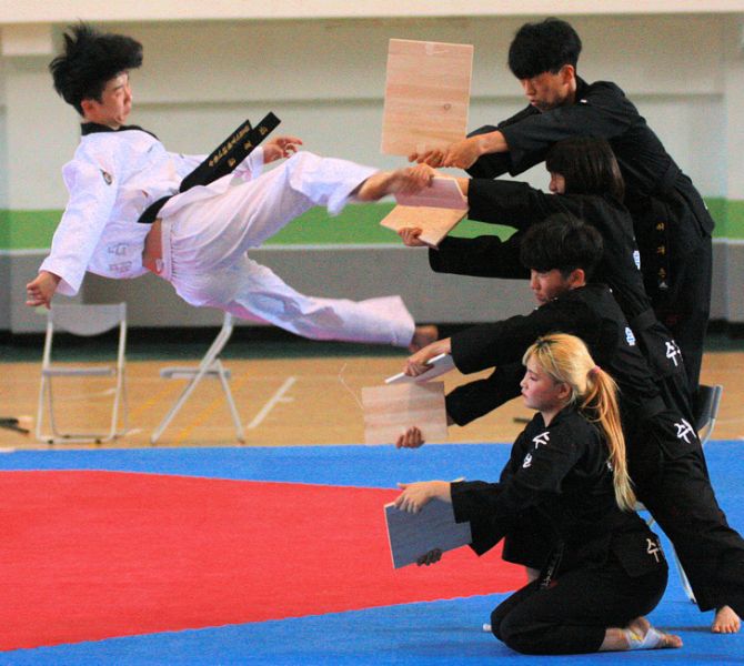 韓國京畿道水原市體育處率該市跆拳道職業表演團精彩空中飛踢木板。圖/高雄市體育處提供