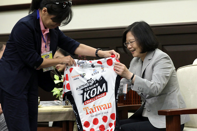 蔡英文總統接下由主辦單位中華民國自行車騎士協會秘書長何麗卿致贈的紀念車衣。總統府／提供。