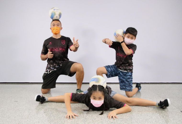 興糖國小教師「小阿諾」吳哲銘與女兒、兒子，進行親子互動式的足球教學。高雄運發局提供