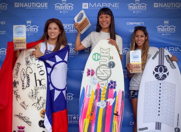 台灣快艇衝浪選手陳美彤 披著國旗上台領獎。大會提供
