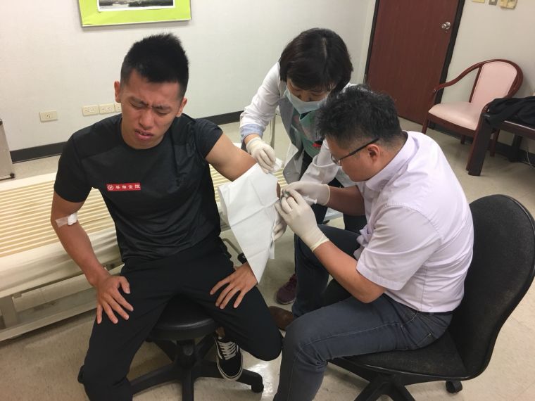 周文毅醫師(右)幫李智凱(左)進行高濃度血小板血漿注射治療。