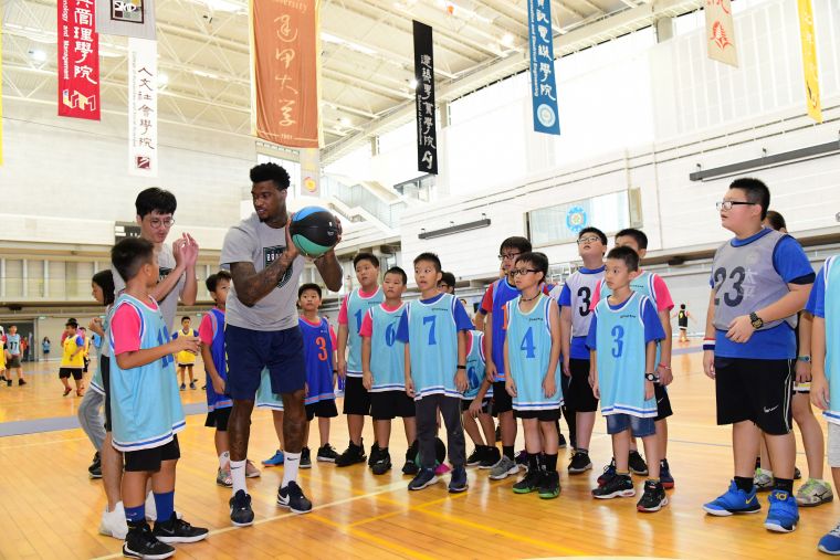 富邦勇士隊球員賈西亞教小朋友投籃技巧。大會提供