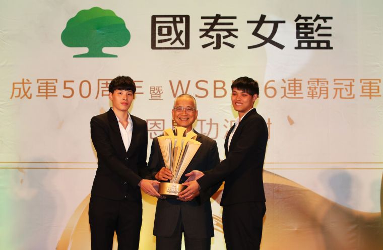 新科WSBL冠軍賽MVP林育庭（左）、鄭伊秀（右）獻冠軍盃給國泰人壽董事長黃調貴。