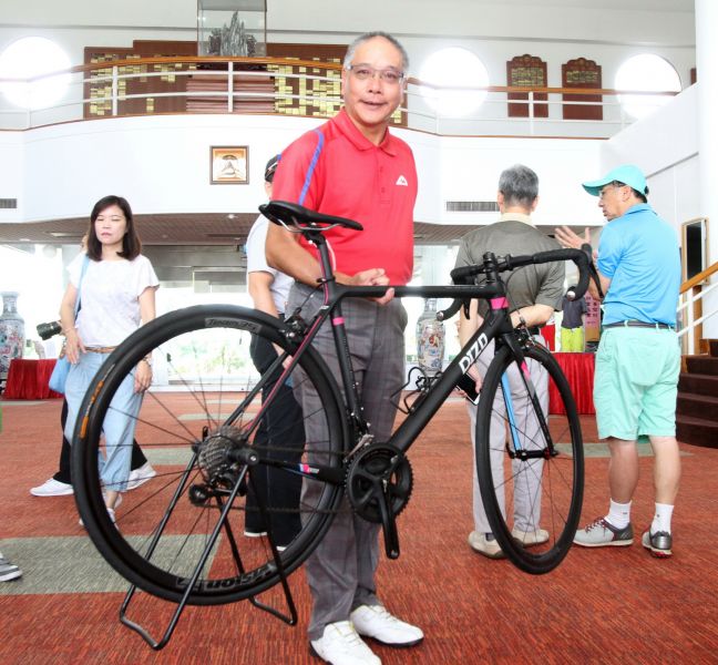 明安國際企業展示輕量高級碳纖公路自行車.TPGA理事長謝錦昇一根手指就能抬起來。鍾豐榮攝