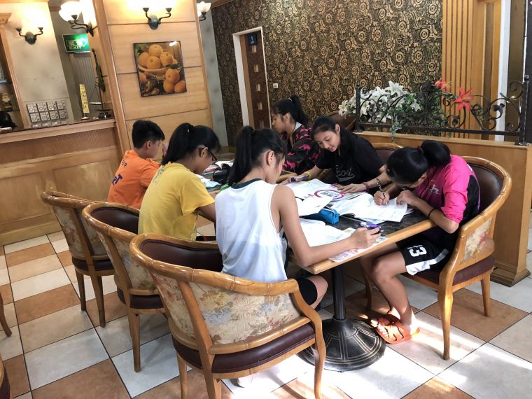 漢口國中女籃球員利用比賽空檔，在下榻的旅館餐廳讀書做功課。