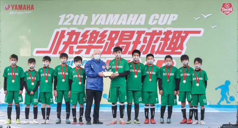 第一次踢進決賽就封王的美育東北虎，從台灣YAMAHA總經理奧谷賢宏手中接過冠軍獎盃。大會提供