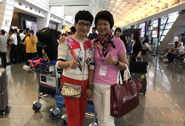 香港隊長張毅（左）與中華婦女會會長何美貞在機場相見歡。