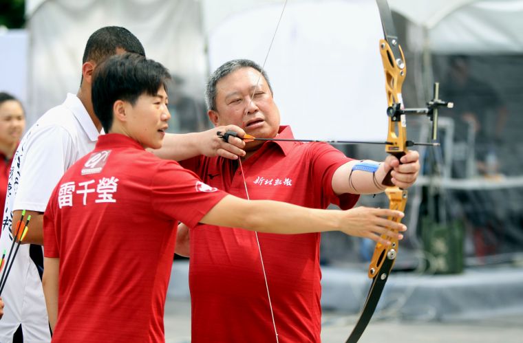 凱撒隊雷千瑩指導中華奧會主席林鴻道射箭。中華企業射箭聯賽聯盟／提供。