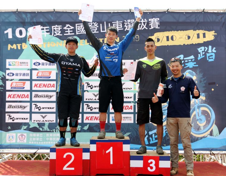 裁判長莫明傑(右)頒獎給男子組下坡賽前三名。中華民國自由車協會／提供。