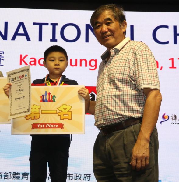 高雄市體育會理事長朱文慶（右）頒在地選手洪建儒獲得U7組慢棋與超快棋雙料冠軍。大會提供