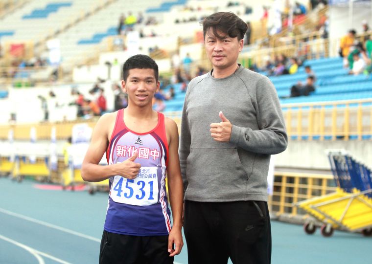 臺南市新化國中教練胡文瑜(右)說，魏浩倫這趟就是來破紀錄的。林嘉欣／攝影。