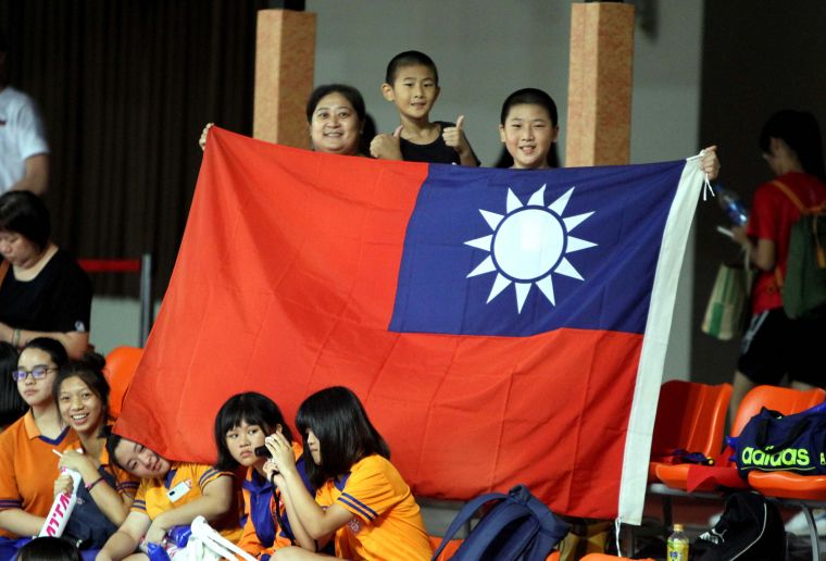 三民國小排球隊蔡鎮宇(右)和蔡鎮謙兄弟和媽媽林馨蘋帶國旗為中華隊加油。林嘉欣／攝影。