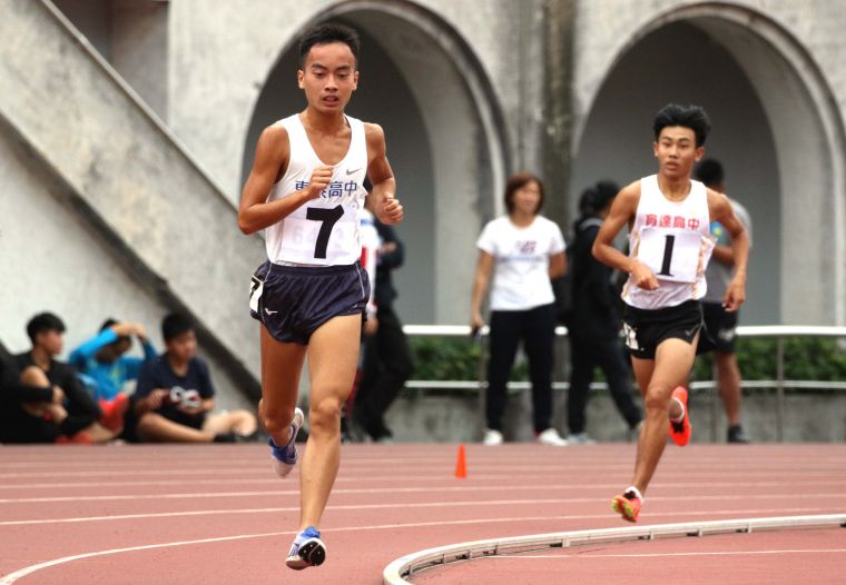 新竹縣東泰高中胡冠愷（前）在5000公尺決賽，最後一圈被桃園市育達高中黃柏憲（後）超車。林嘉欣／攝影。