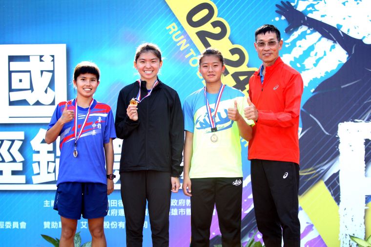 臺灣體大鄭宜瑄（左二）首次比1500m便奪金破大會，教練許績勝（右）也替她開心。林嘉欣／攝影。