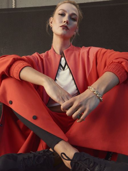 adidas x Karlie Kloss 2021春季聯名系列橘紅短版寬袖外套，採雙面針織、立體布料異材質拼接撞色設計，搭配兩側採用開放式鈕扣設計的橘色寬褲，為造型增添亮點。官方提供