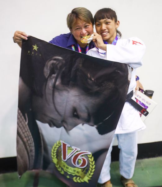 許琳宣(右)與教練蔡宜芳開心展示六連霸海報。大會提供