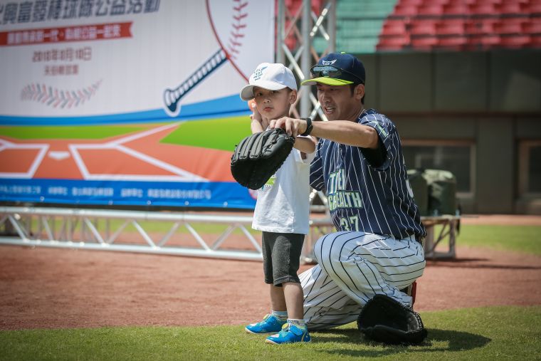 臺北興富發棒球隊球員認真指導小朋友。台北市體育局提供