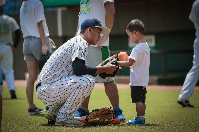 臺北興富發棒球隊球員認真指導小朋友。台北市體育局提供