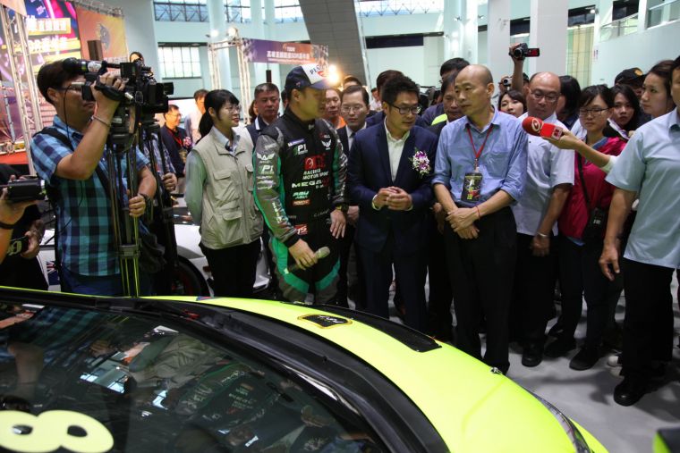 市長韓國瑜在現場參觀導覽人員介紹展示的賽車。大會提供