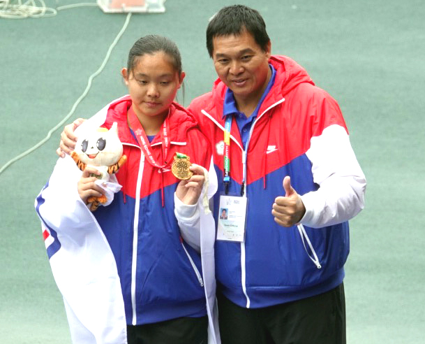 親眼見證女兒洪吉嫻(左)拿到國際賽首金，洪寶全超開心。田徑協會／提供。