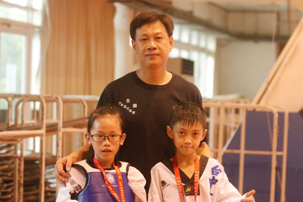 臺中市教練謝世韋（後）和奪得金牌的子弟陳奕溱（左）、林群盛（右）合影。