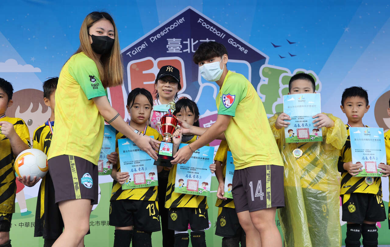 臺北熊讚女子足球隊王羿婷(左)、楊萱頒獎給小小球員。大會提供