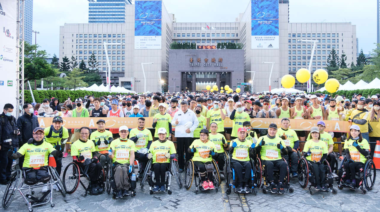 臺北市長柯文哲與輪椅半程馬拉松組選手在起跑拱門前合影。中華民國路跑協會提供