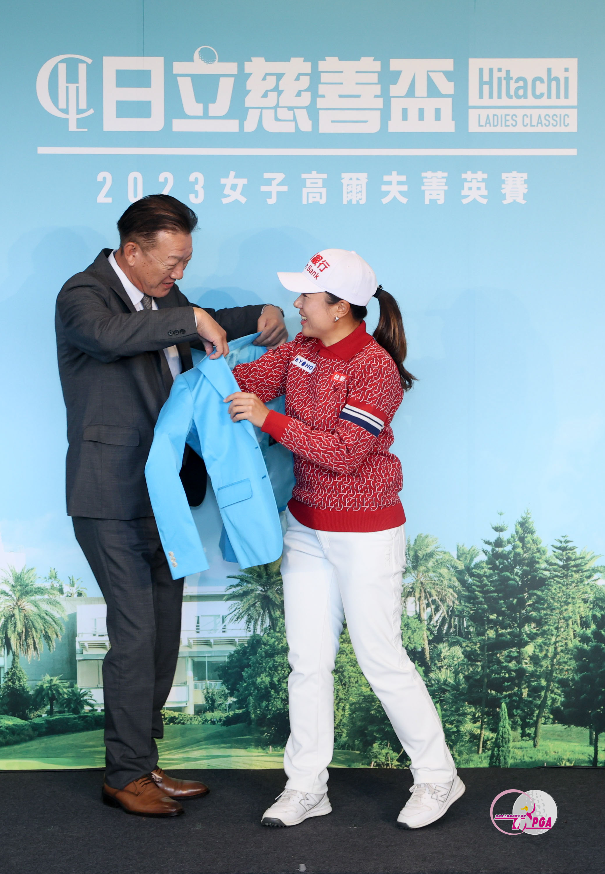 台灣日立江森自控股份有限公司董事長菊地正幸(左)為2022冠軍選手蔡佩穎右穿上冠軍夾克。TLPGA提供 