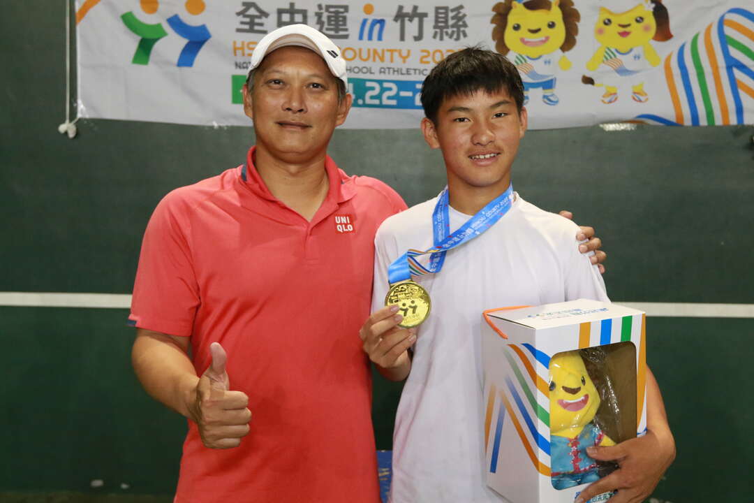 手握金牌的陳冠守和教練鄭偉揚(左)。四維體育推廣教育基金會提供