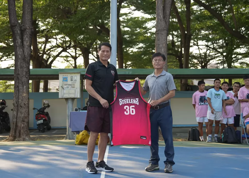 總教練邱大宗致贈球衣給陽明國中男籃總教練吳昌和。官方提供