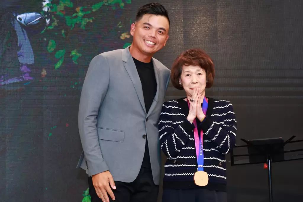 杭州亞運銅牌得主洪健堯(左)將亞運銅牌獻給三花棉業施純鎰創辦人夫人施黃純子。鍾豐榮攝影