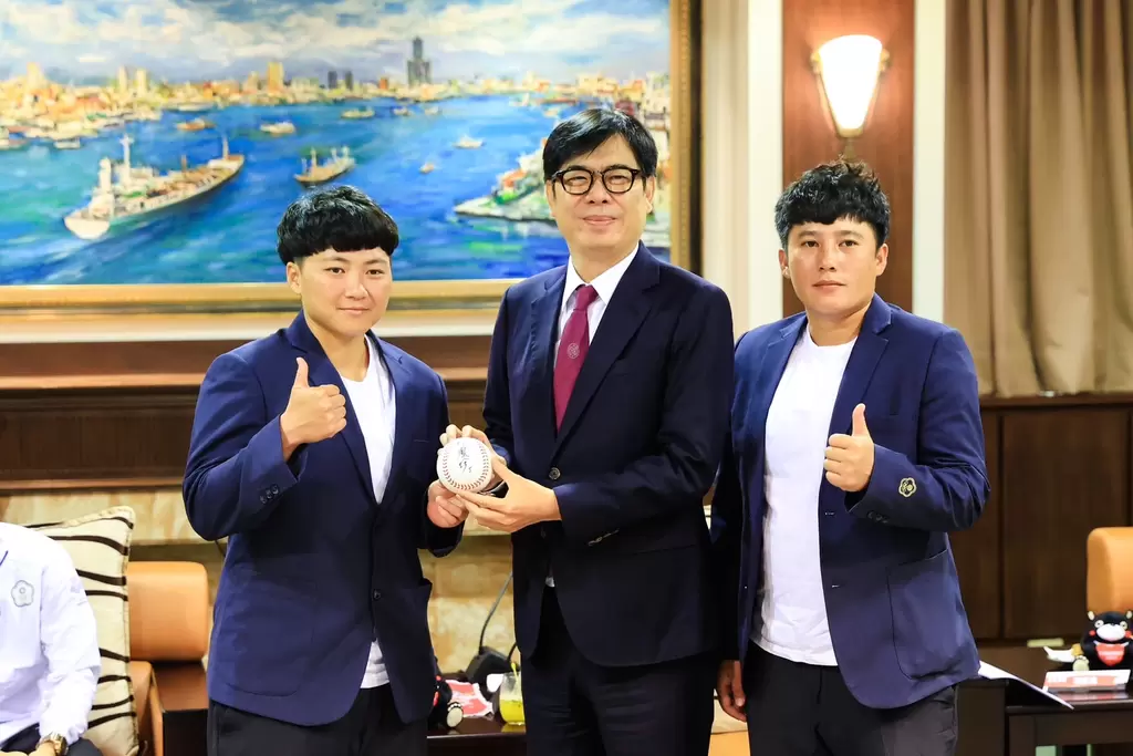 亞運銅牌壘球選手林鳳珍（左1）與蘇奕璇（右1）共同獻上簽名球給市長陳其邁。  高雄新聞局／提供