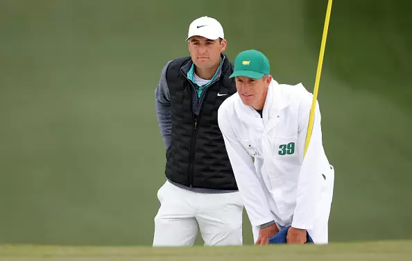 Scottie Scheffler and caddie Ted Scott line up a putt on the 7th green during the third round of the Masters at Augusta National GC on April 9, 2022 in Augusta, GA. (Photo by Jamie Squire via Getty Images)