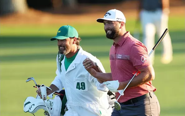 Jon Rahm and his caddie Adam Hayes celebrate as they approach the 18th green at Augusta National on Apr 09, 2023 in Augusta, GA. (Photo by Andrew Redington via Getty Images)