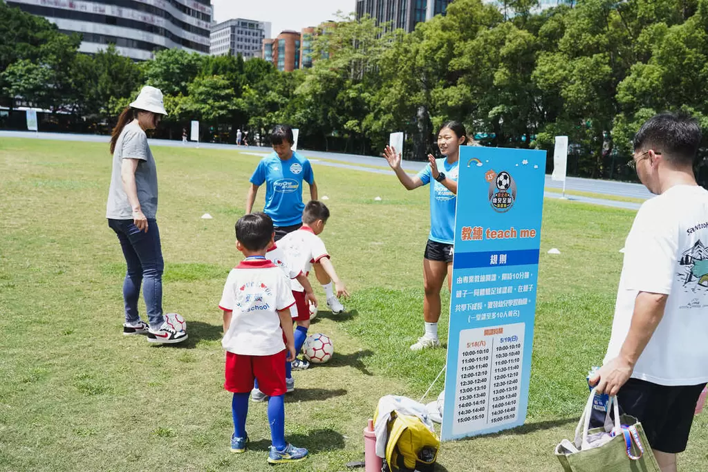 臺北熊讚Playone女足隊球員在臺北市幼兒足球錦標賽場外設遊戲攤位與小朋友快樂踢球。臺北市體育局提供