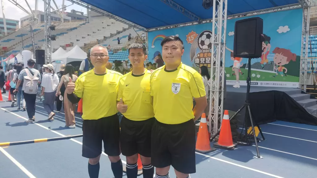 賈偉強(左起)父子三人賈乂愷與賈乂穎攜手在臺北市幼兒足球錦標賽擔任裁判。臺北市體育局提供