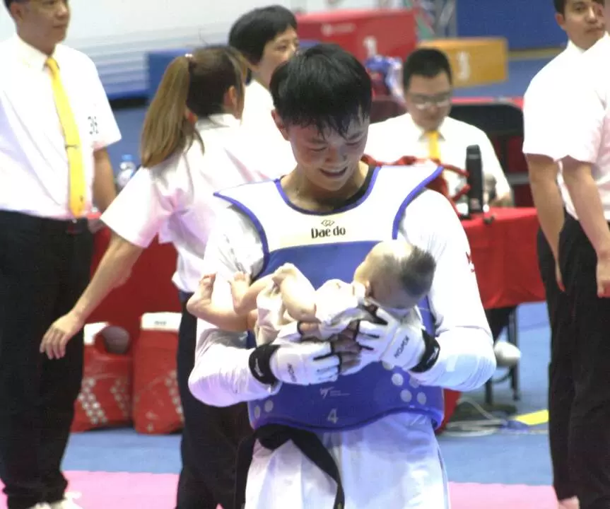  黃鈺仁打完最後一場全大運後開心抱著5歲兒子亮相。詹健全攝