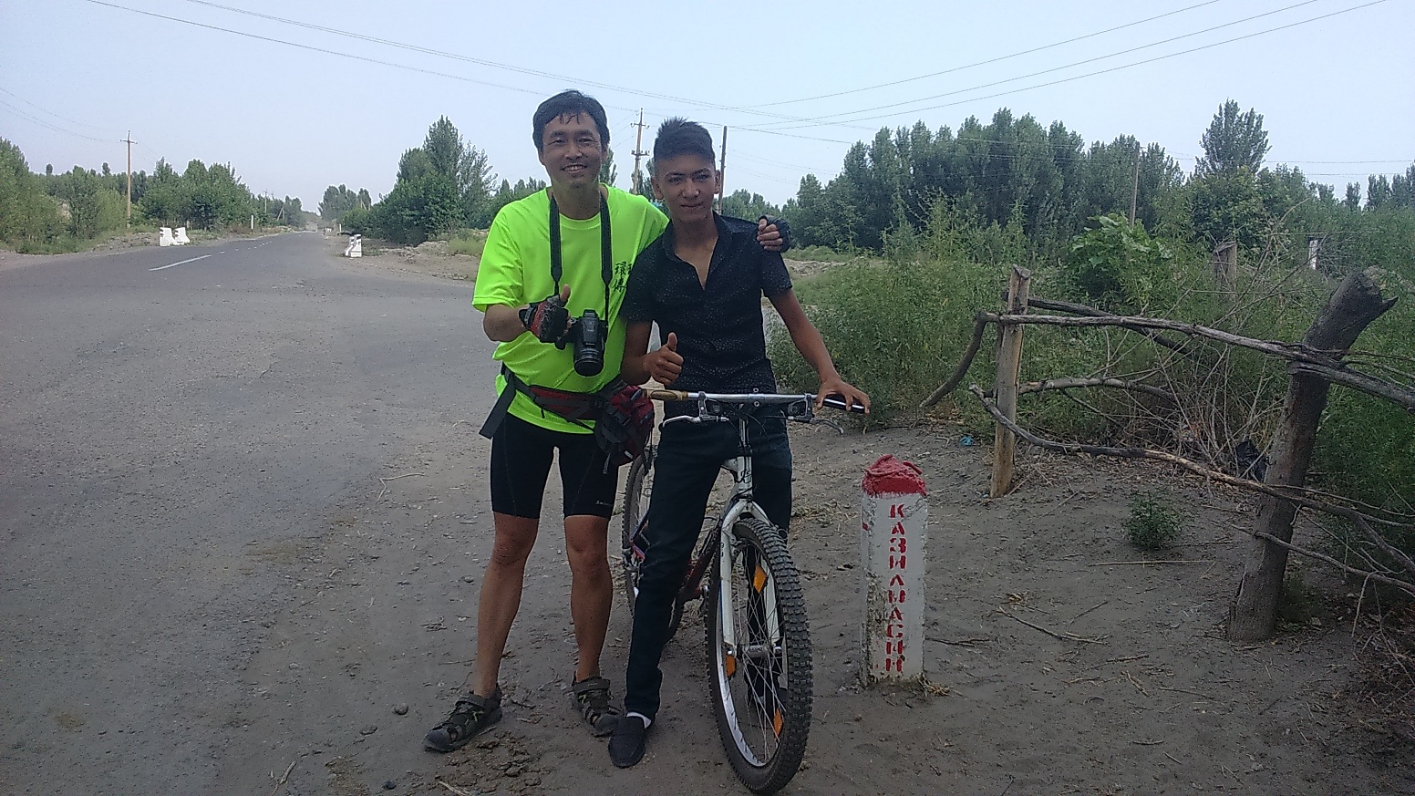 在烏茲別克有當地騎士(右)自動加入陪騎行列，左為陳守忠。單車環球狀遊聯盟提供