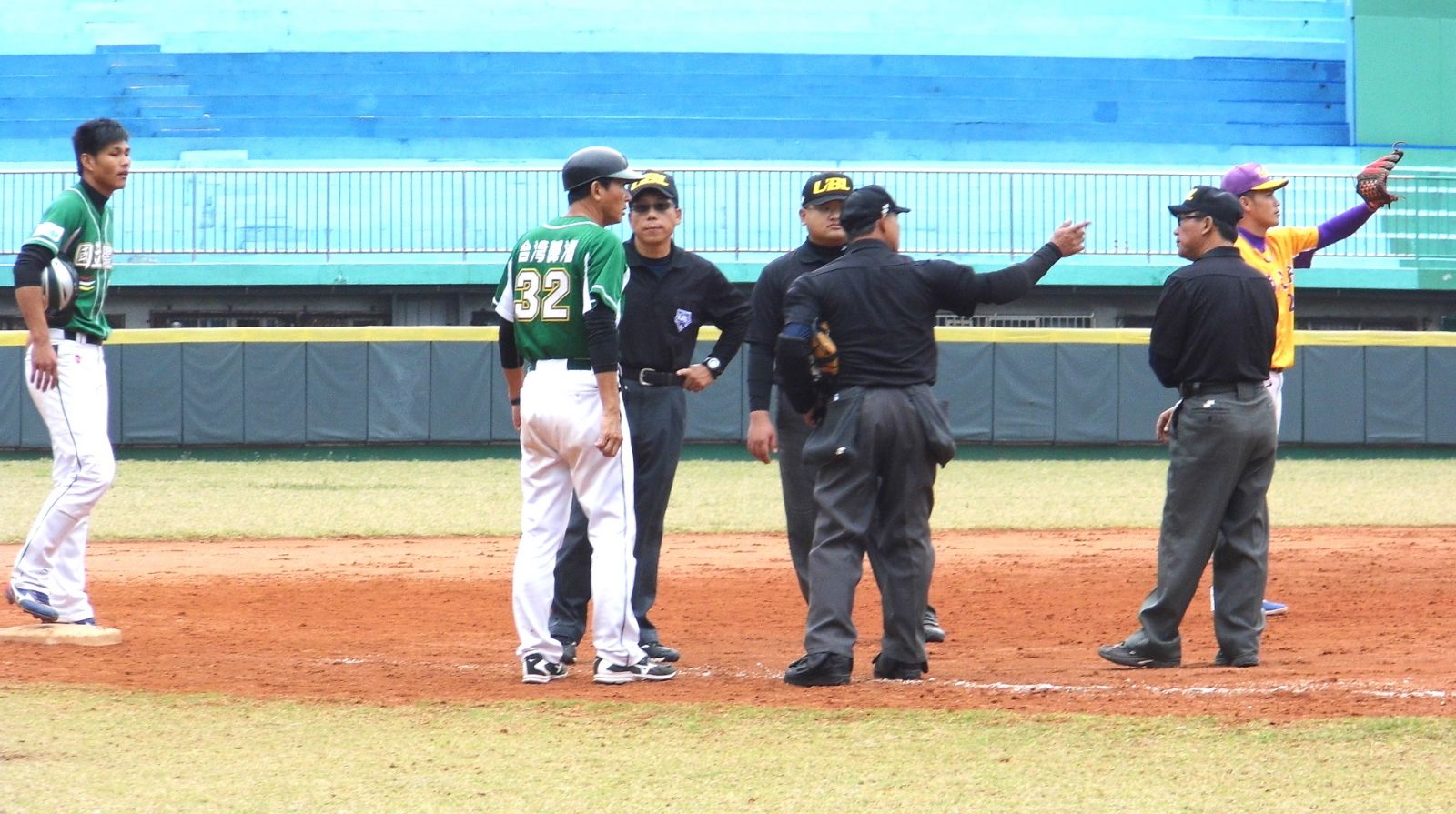 裁判向國體總教練龔榮堂說明引用規則使跑者回到二壘。