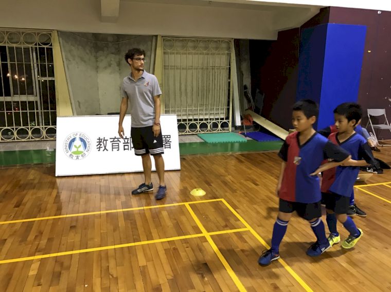 外國教練用足球的「國際語言」和小球員溝通。